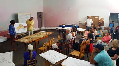 Final presentation of Oldřich Hozman at the school in Reno. Models and an architectural study of the school campus are displayed on tables.