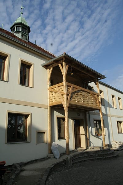 Dostavba balkónu nad hlavním vstupem do hlavní budovy v areálu Camphillu. Konstrukce je postavena tradičními tesařskými postupy z modřínového dřeva.